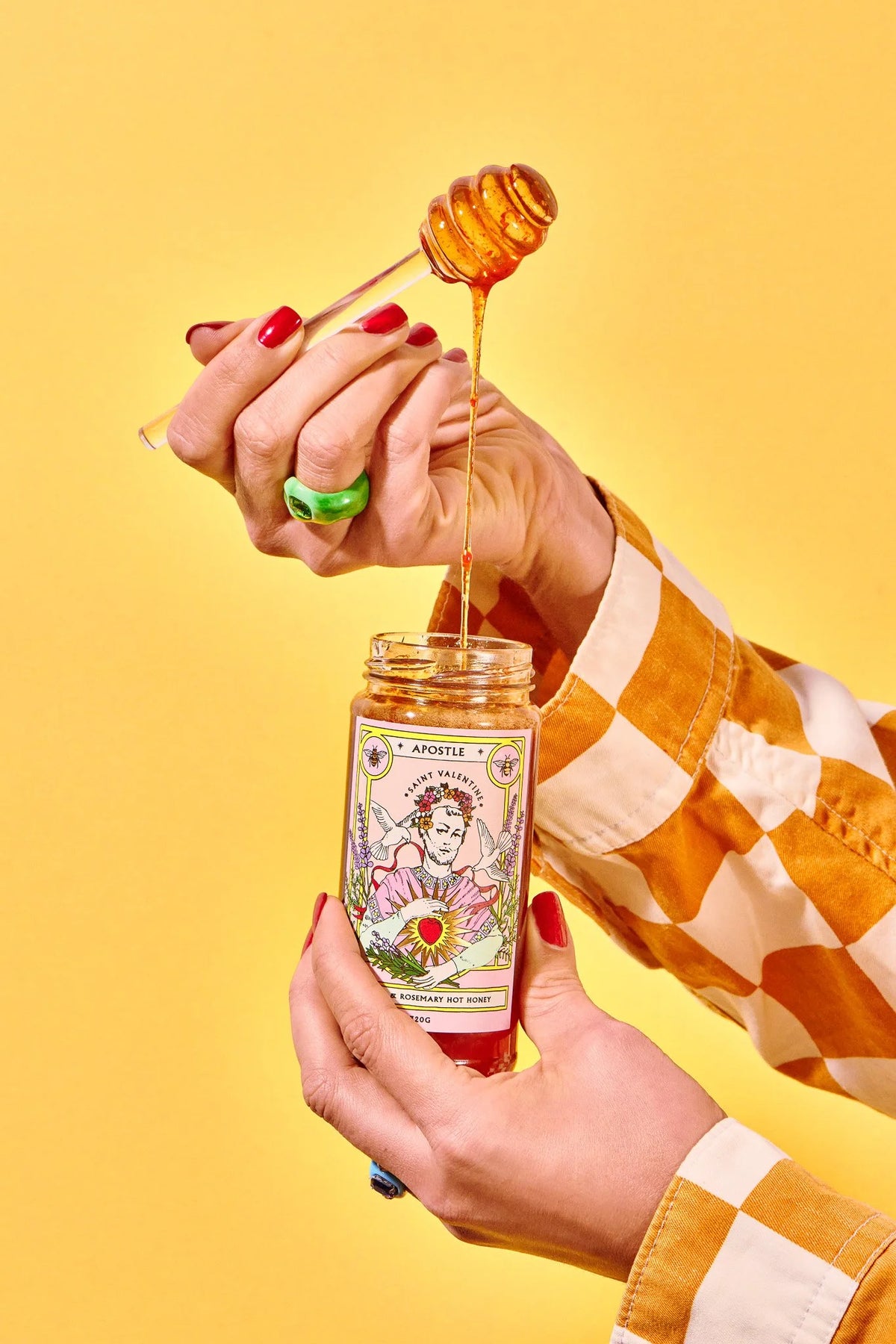 Hands drizzling Apostle lavender and rosemary hot honey