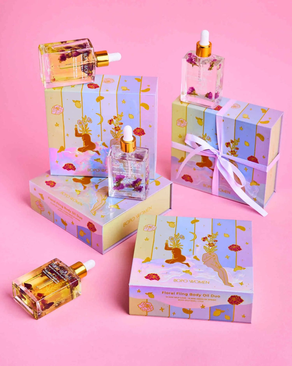 Floral Fling gift sets and perfume oils arranged on a pink background
