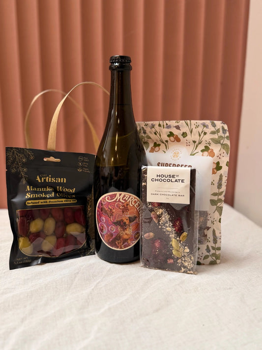 Contents of the Boujee Basket: red wine, chocolates and snacks