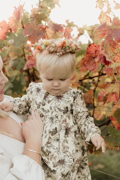 Toddler wearing a dried flower crown in an autumn garden