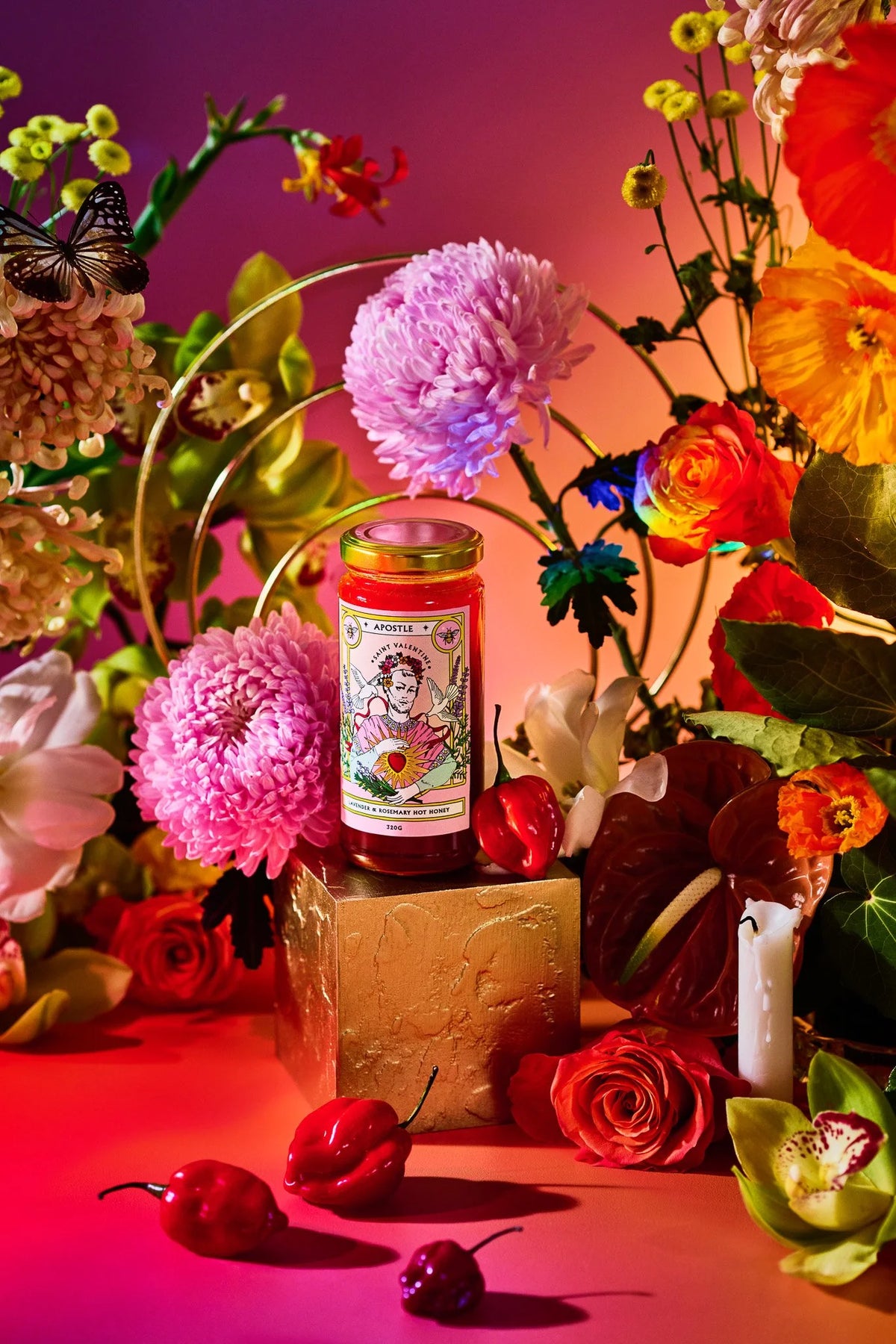 Apostle hot honey jar styled with bright pink and red flowers