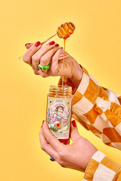 Hands drizzling Apostle lavender and rosemary hot honey