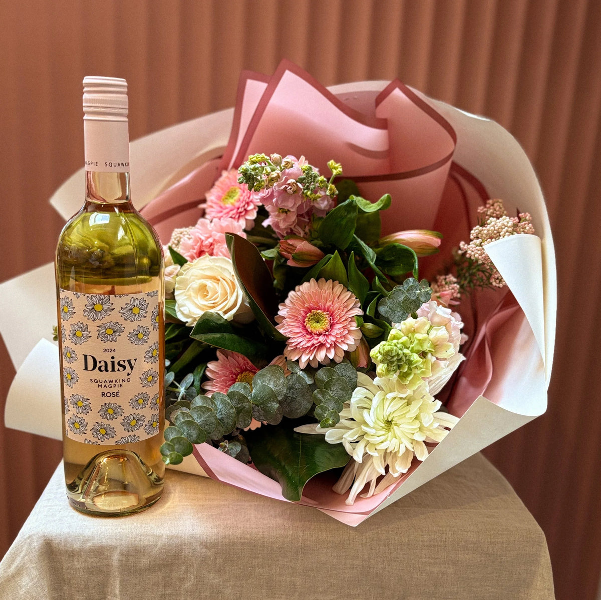 Squawking Magpie Daisy wine with a pink gerbera and rose bouquet