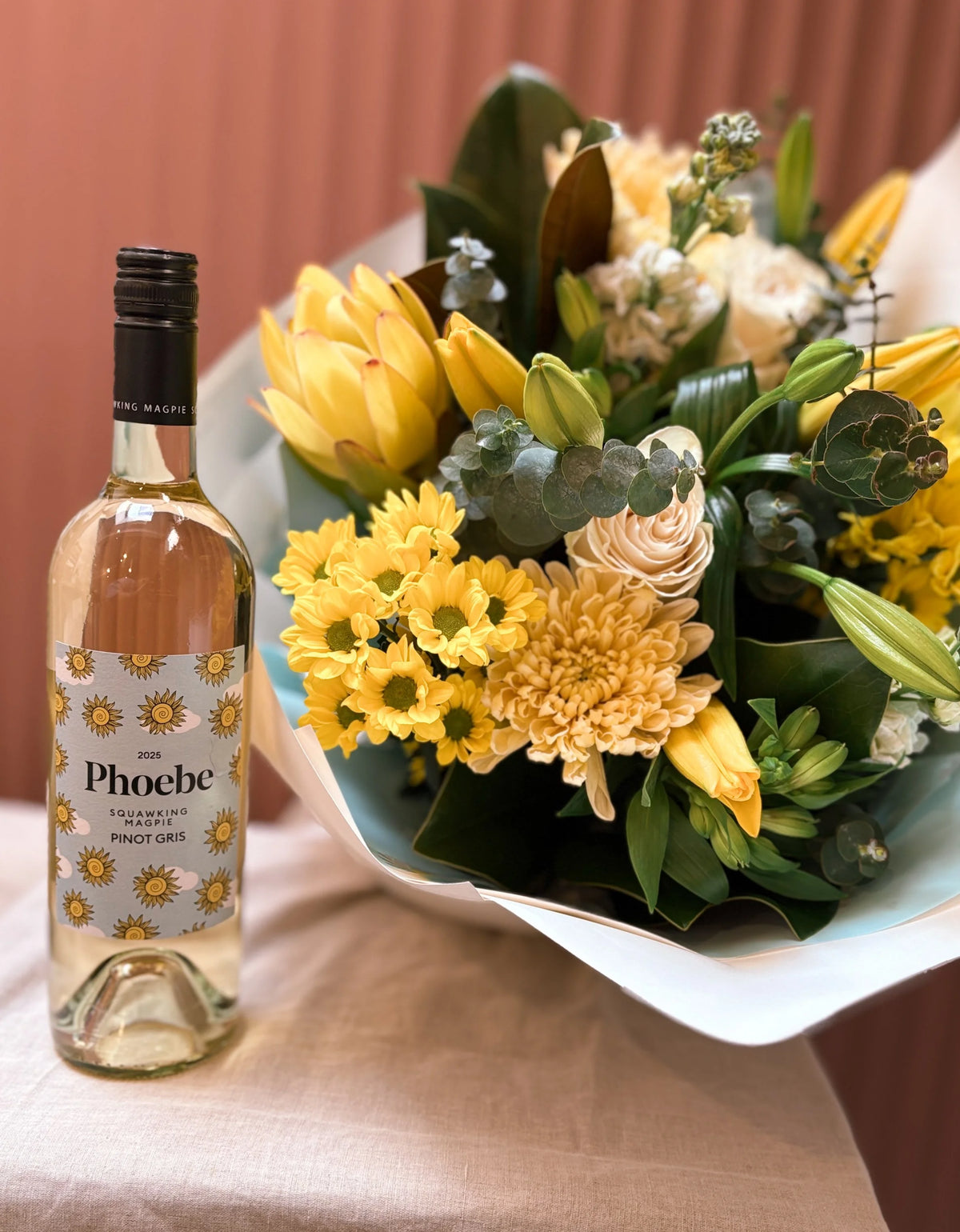 Phoebe wine bottle with a yellow tulip and sunflower bouquet