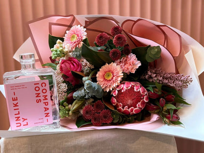 Unlikely Companions pink gin with a protea and rose bouquet