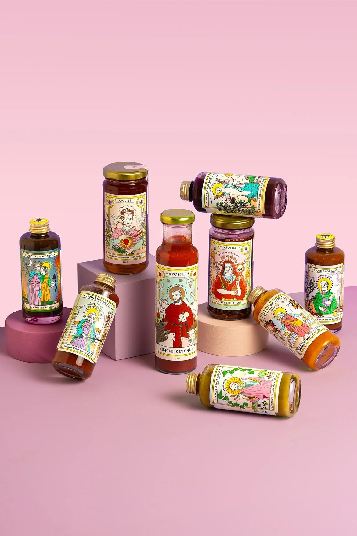 Apostle hot sauce range bottles arranged on pink stands
