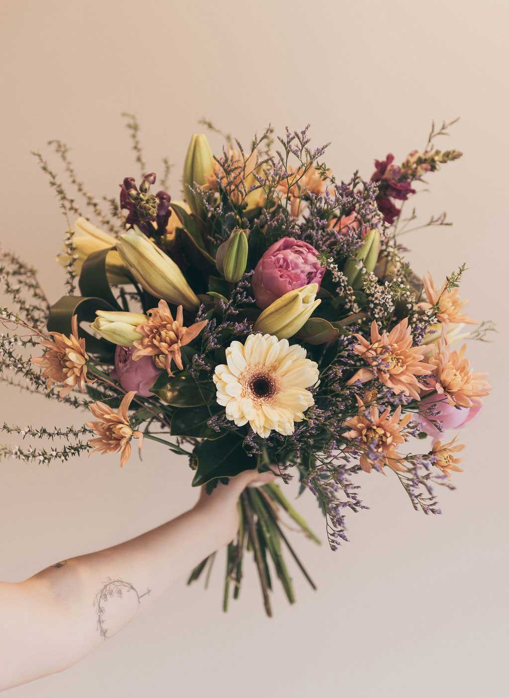 Hand-held seasonal bouquet with gerbera and dried grasses