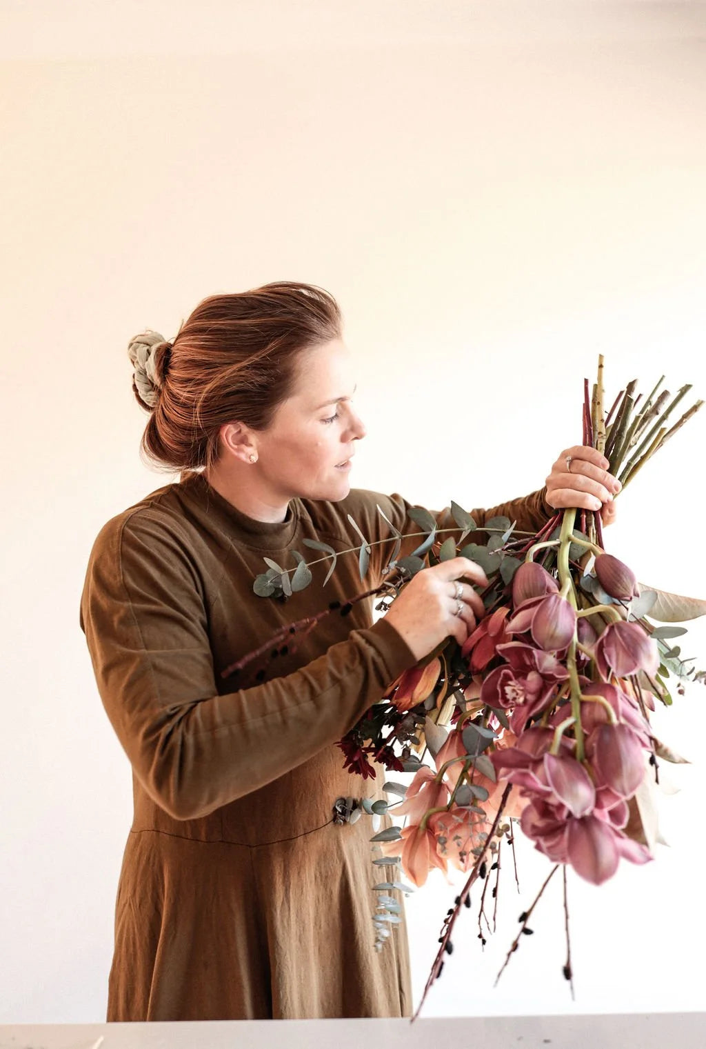 Florist in Hawke's Bay arranging purple flowers into a bouquet